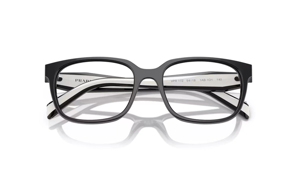 عینک طبی پرادا فریم کائوچویی مربعی از روبرو مشکی به همراه دسته های سفید مشکی با لوگوی PRADA - عکس از زاویه بستخ عینک